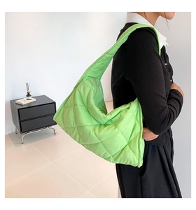 Detalle del bolso hobo de nailon acolchado verde neón con costuras de rombos y asa ancha