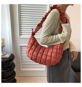 Detailed shot of terracotta quilted dumpling bag with stylish ruffled shoulder strap detail