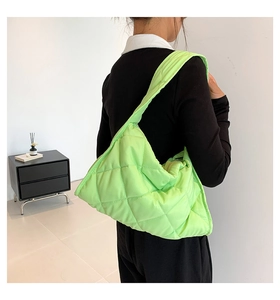 Bolso tote acolchado verde fluorescente con costuras de diamante llevado al hombro
