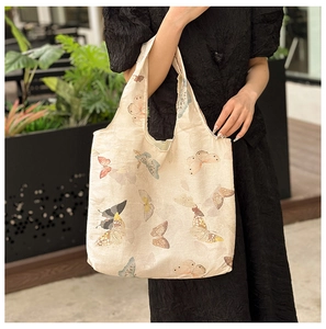 Detailed texture of beige canvas tote bag featuring vintage aesthetic butterfly prints