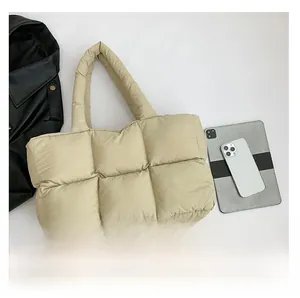 Detailansicht von oben: Große gesteppte Daunentasche in Beige mit Tablet und Handy