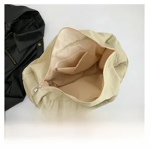 Detailansicht der beigen Stepptasche mit großem Fassungsvermögen und innerem Reißverschlussfach