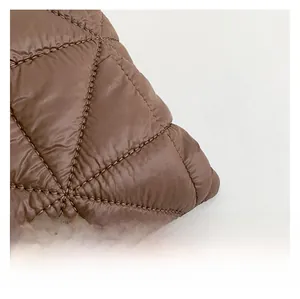 Macro shot of brown quilted diamond pattern fabric with smooth satin finish and clean seams