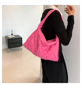 Primer plano del bolso de hombro de nailon acolchado rosa brillante con relleno