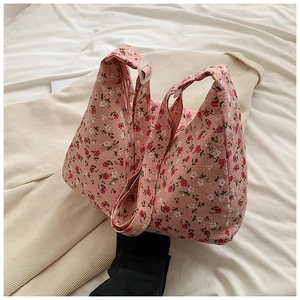 Détail montrant la texture du tissu floral et le motif rose du sac cabas