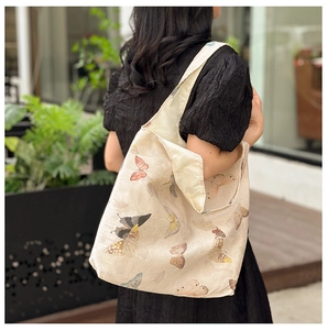 Detail view of large tote bag with colorful butterfly prints and natural texture