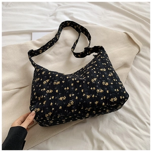 Vue détaillée du sac cabas en tissu noir à fleurs jaunes et large bandoulière réglable