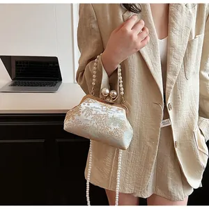 Detail of Chinese style embroidery handbag with pearl handle and traditional silk pattern