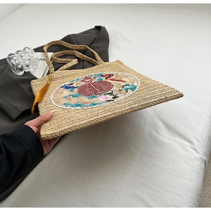 Detail of straw woven tote with Chinese dragon embroidery and yellow silk tassel