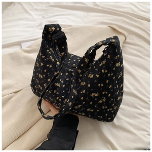 Détail du sac cabas floral montrant le tissu texturé et la bandoulière réglable