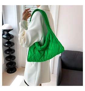 Detalle del bolso tote acolchado verde que muestra el patrón de rombos y textura suave