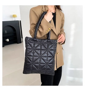 Detail view of large black quilted tote bag with diamond stitching on lightweight nylon