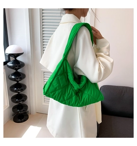 Detalle del bolso de hombro en nylon verde brillante con elegante diseño acolchado