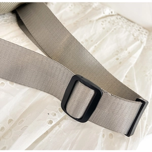 Close-up of adjustable woven shoulder strap with plastic buckle for canvas sling bag