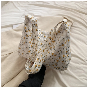 Détail du sac cabas à fleurs jaunes montrant le tissu en coton et la large bandoulière