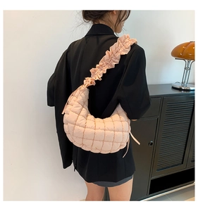 Peach pink quilted dumpling bag with ruffled shoulder strap and square pattern texture
