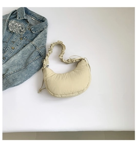 Close-up of cream pleated moon bag with ruffled shoulder strap and nylon texture
