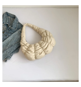 Detail of off-white quilted cloud bag with pleated PU leather texture and half-moon shape