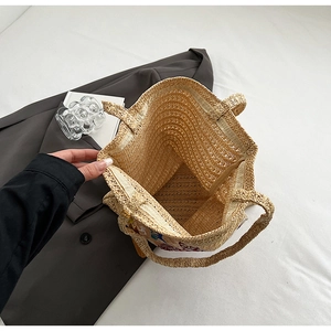 Detailed view of beige woven tote bag with internal zipper pocket and spacious interior