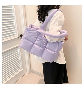 Detailansicht der fliederfarbenen Stepptasche mit weicher Textur und breitem Schultergurt