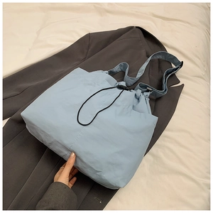 Detail of light blue waterproof nylon tote with adjustable black drawstring closure