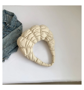 Close-up of beige pleated cloud bag with soft PU leather texture and curved handle