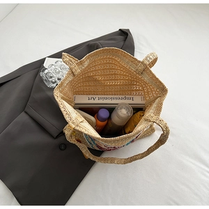 Detail of spacious straw tote bag interior showing capacity for books and accessories