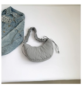 Detail of grey ruched cloud shoulder bag featuring quilted texture and soft padded strap