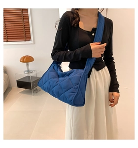 Détail du sac hobo matelassé bleu avec surpiqûres en losanges et large bandoulière souple