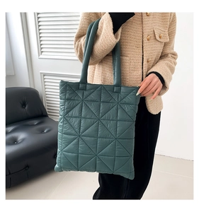Detailed view of the dark green quilted tote bag featuring classic diamond stitching texture