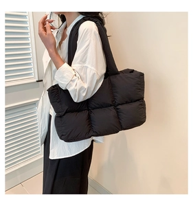 Detailansicht der schwarzen gesteppten Puffer-Tasche aus wasserfestem Nylon am Modell