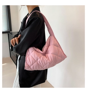 Detalle del bolso hobo acolchado rosa de gran capacidad llevado por una modelo real