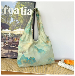 Detail shot of light green canvas tote bag featuring an artistic ink mountain landscape