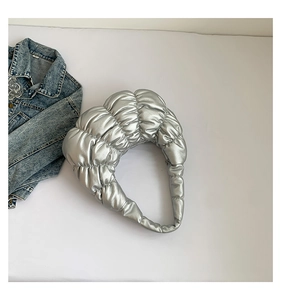 Macro view of metallic silver crescent cloud bag with quilted pleats and soft texture