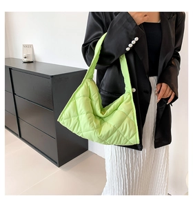 Primer plano del bolso de hombro de nailon acolchado verde neón en un modelo elegante