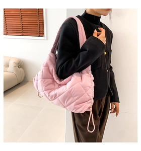 Detailansicht der rosa gesteppten Puffer-Umhängetasche mit verstellbarem Kordelzug und Gurt
