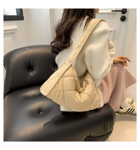 Gros plan détaillé du sac bandoulière matelassé crème avec texture de couture douce