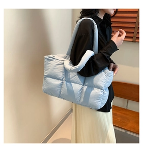 Detailansicht einer hellblauen gesteppten Daunentasche aus Nylon mit weicher Textur