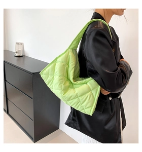 Modelo con bolso tote acolchado verde fluorescente en un estudio de moda minimalista
