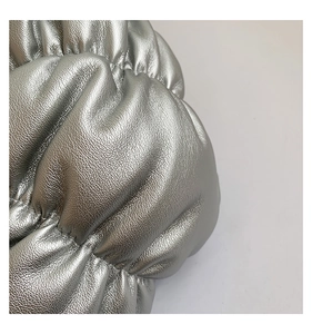 Close-up of metallic silver faux leather texture with elegant ruched cloud pleats