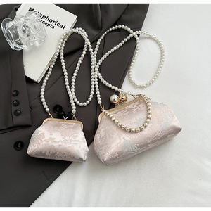 Detail of pink brocade cheongsam handbags with traditional embroidery and pearl chain