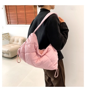 Modell trägt eine rosa gesteppte Bubble-Hobo-Tasche mit weichem Schultergurt