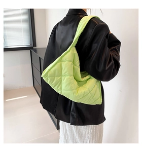 Detalle del bolso tote acolchado verde neón con textura de nailon y correa ancha