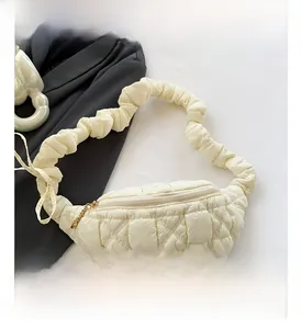 Detail of cream quilted cloud bag featuring a scrunchie strap and gold chain zipper