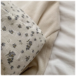 Détail du tissu gaufré du sac avec motif floral bleu et texture de coton doux