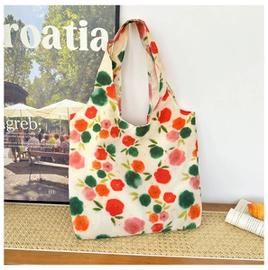 Detailed close-up of a floral canvas tote bag on a wooden table with art poster background