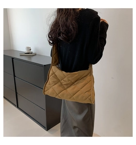 Sac bandoulière matelassé en nylon kaki porté par un mannequin pour référence de style