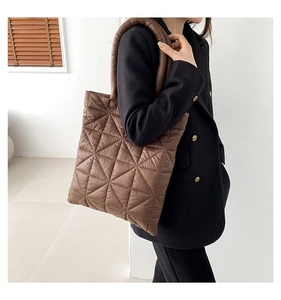Detailed close-up of brown quilted tote bag with geometric stitching and down-like texture