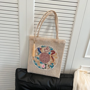 Beige woven tote bag with Chinese dragon embroidery and long straps for daily commute