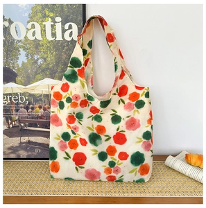 Detail of canvas tote bag featuring vibrant floral prints on a rustic wooden table setup